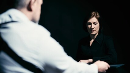 Wall Mural - Police detective showing photos to a woman, asking questions, interrogation