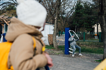 grandmother and granddaughter go in for sports on simulators outdoors to maintain health, cohesion. the concept of a healthy lifestyle in the older generation and family, playing sports together