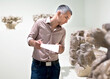 © JackF - Adult man is visiting museum and looking at the exposition with information brochure indoor.