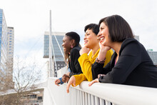 Positive Multiethnic Women Leaning On Bridge Fence