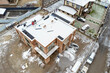© Smole - Roofing construction worker installing a flat roof. Bright blue sky in the background.