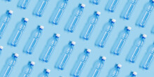 Pattern With Blue Plastic Bottles On Blue Paper Background, Top View Empty Plastic Bottle For Water Half Litre, Minimal Image. Pollution, Plastic Garbage, Environmental Protection Concept