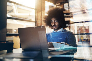 Hes hard at work as always. Shot of a handsome young businessman using a laptop in his office at work.