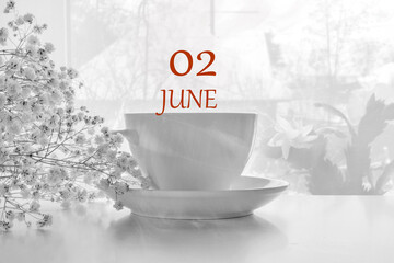 calendar date on light background with porcelain white tea pair and white gypsophila with copy space. June 2 is the second day of the month