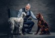 Elderly man with his purebred dogs sitting on armchair