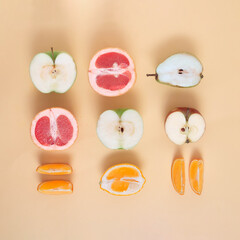 Neatly arranged fresh fruit on sandy yello bacground. Minimal flat lay.