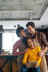 Wall Mural - happy multiethnic family in love together in kitchen. parents child together concept