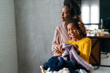 Happy multiethnic teenage children are smiling while do household with mother at home.