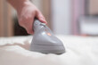 © Natali - Woman ironing bed linen with a steamer close up.