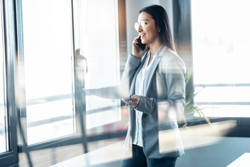 Wall Mural - Beauty business woman using her digital tablet while sitting on a desk in a modern startup office.