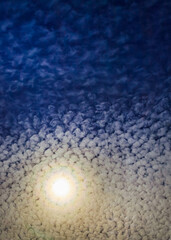 Wall Mural - mackerel sky, white small rounded puffs clouds floating around the soft focus on golden bright sun c
