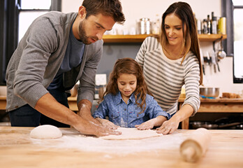 Wall Mural - Adding the finishing touches. Shot of a happy family of three baking together in the kitchen.