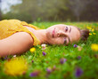 © Thurstan H/peopleimages.com - I found my bliss in a field full of flowers. Portrait of a young woman lying down in a field of grass and flowers.