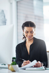 Wall Mural - Putting in the effort to become a leader. Shot of a young businesswoman writing notes while working in an office.