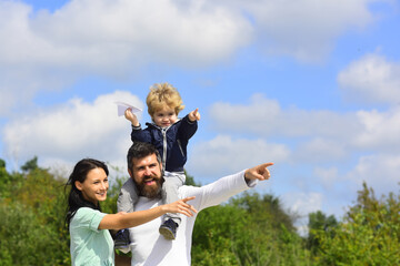 Sticker - Child playing with toy airplane and dreaming future, concept of dreams and travels. Happy family portrait having fun together with toy paper plane. Father mother and child son.