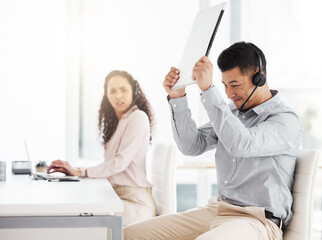 Wall Mural - This darn thing wont work. Shot of a young call centre agent angrily smashing a laptop while working in an office.