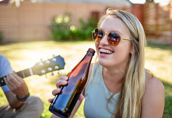 This is the life. Cropped shot of an attractive young woman enjoying a few drinks with friends outside in the summer sun.