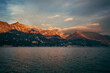 sunset over the lake iseo in italy with pink clouds over the mountains