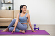 © Chanakon - Young asian sport woman sitting practicing yoga lesson. Stretching body training workout on yoga mat at home for good health and body shape.