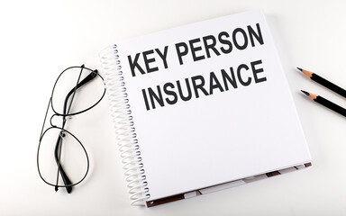 Wall Mural - Notepad with text KEY PERSON INSURANCE . White background. Business concept