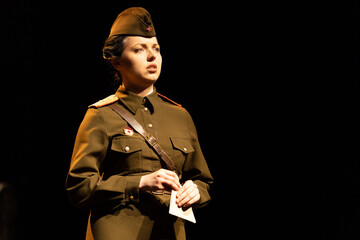 Actress in military uniforms of the Soviet army of World War II play a performance on stage in the theater