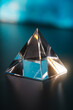 Transparent triangular prism on the table. Prism for design. Prism in the shape of a pyramid