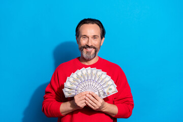 Sticker - Portrait of attractive cheerful man holding in hands fan cash atm isolated over bright blue color background