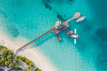 Beautiful Aerial View Of Maldives Jetty Seaplane Top View With Wooden Boat And Tropical Beach. Luxury Tropical Resort Or Hotel With Water Villas And Beautiful Beach Scenery. Amazing Bird Eyes View