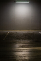 Canvas Print - Vertical shot of an empty parking lot with an overhead dim light