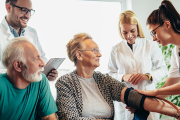 Wall Mural - Group of young doctor during home visit senior people, control blood pressure.