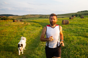 Wall Mural - man running with his dog at sunset healthy active lifestyle