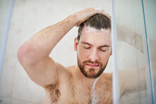 Start Your Day On A Refreshing Note. Cropped Shot Of A Handsome Young Man Having A Shower At Home.