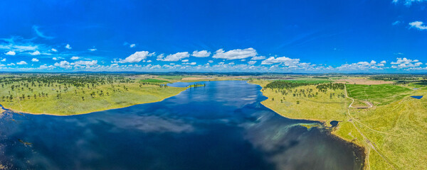 A big green field at Rangers Vally Cattle with a blue sky in Australia with a river next to it