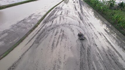 Wall Mural - Farmer tractor plowing soil to prepare the field for cultivate rice in plantation at countryside