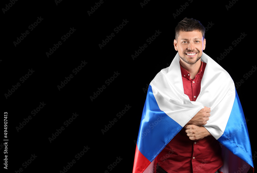 Handsome man with flag of Russia on dark background