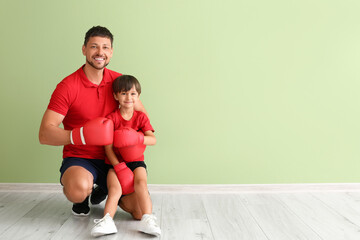 Poster - Little boy with boxing trainer near green wall