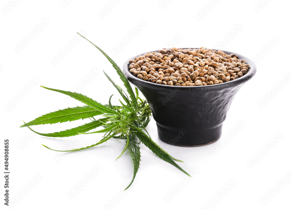Bowl with hemp seeds on white background