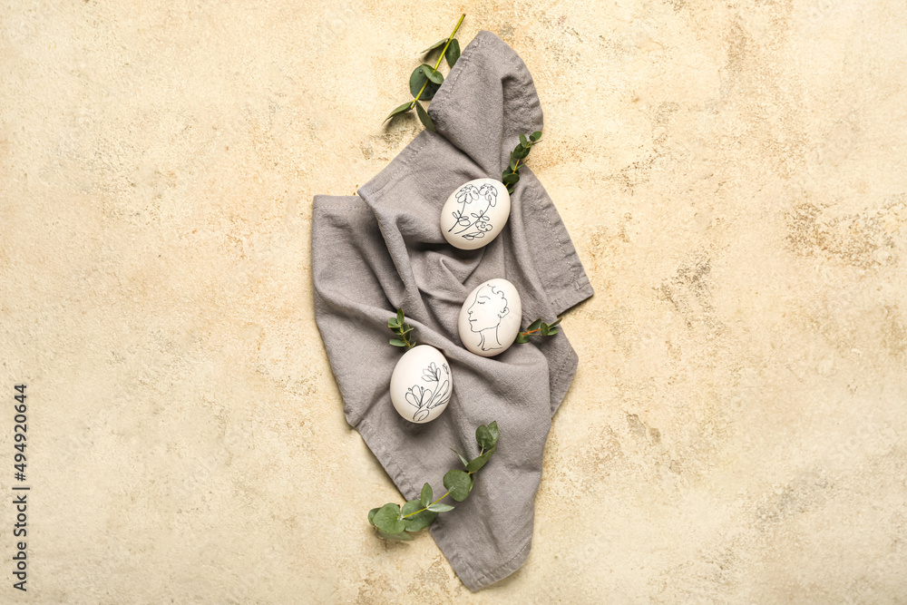 Composition with painted Easter eggs and branches on beige background