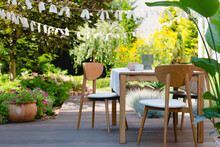 Wooden Table And Chairs In A Summer Garden