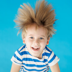 Wall Mural - Happy child shouting against blue paper background