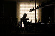 © Vladimir Ivanovic/Wirestock Creators - Silhouette of the man sitting in the cafe.
