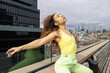 © Mat Hayward - Mixed race woman with black and brown curly hair wearing summer fashion outside with cityscape view of New York City.