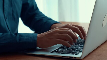 Wall Mural - businessman hand work on capable laptop computer at office table close up shot and selective focus a