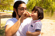 © Antonio Tanaka - portrait of a Hispanic father and baby in a park smiling and having fun