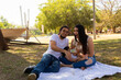 © Antonio Tanaka - Young Hispanic parents playing with their one year old baby in a park