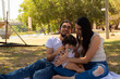 © Antonio Tanaka - Young Hispanic parents playing with their one year old baby in a park