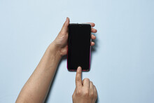 Top View Shot Of A Person Holding A Locked Black Phone On A Blue Background