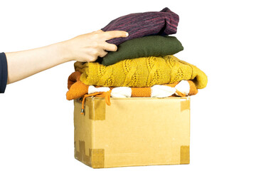 closeup woman putting shirt in carton box with used clothes for donation, collection and support of war victims, helping people, charity