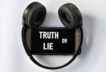 TRUTH OR LIE - words on a smartphone with headphones