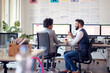 © luckybusiness - Two young business coworkers discussing together